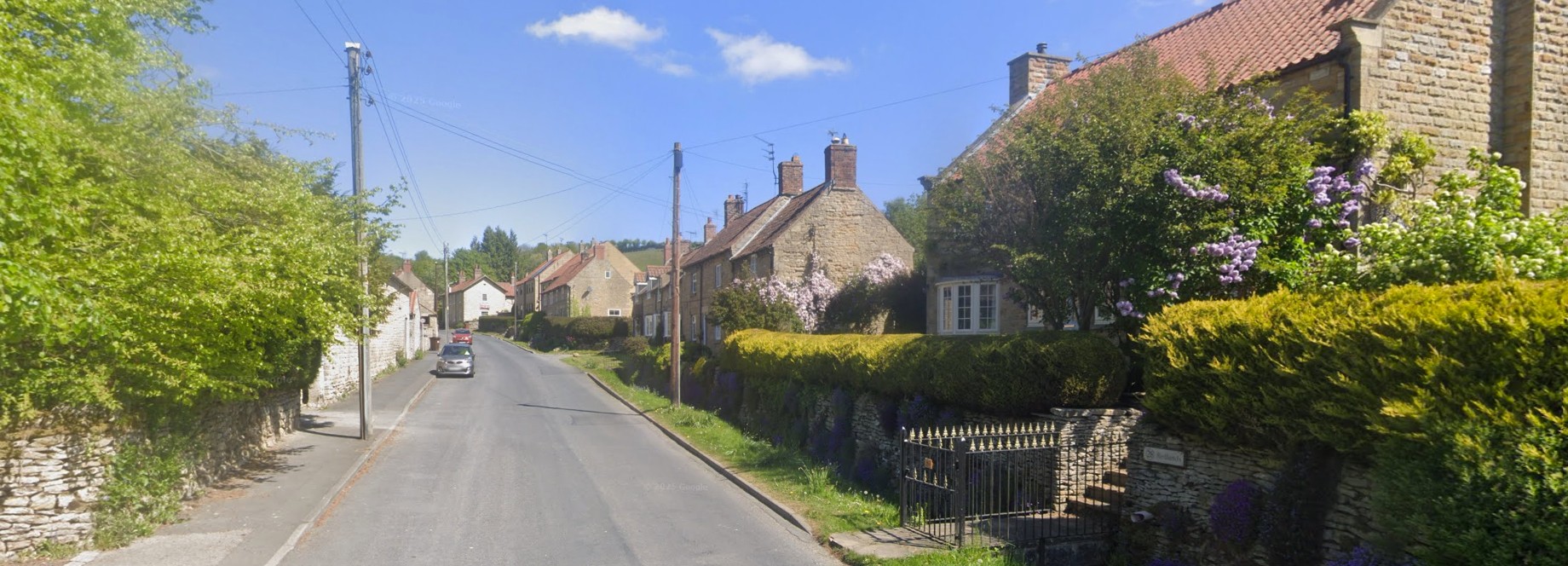 Ebberston village street, with sandstone cottages and pantile roofs under a summer sky